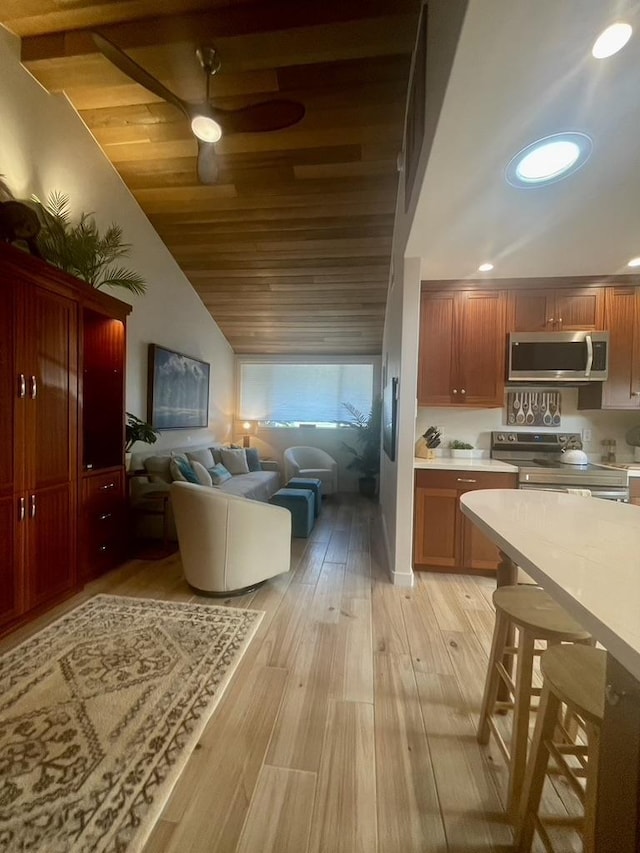 kitchen with light wood finished floors, wood ceiling, appliances with stainless steel finishes, open floor plan, and light countertops