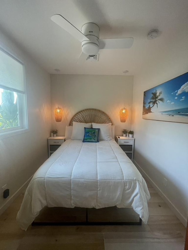 bedroom with a ceiling fan, visible vents, and baseboards