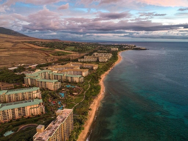 aerial view at dusk featuring a water view