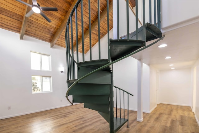 staircase featuring wood-type flooring, high vaulted ceiling, wooden ceiling, beamed ceiling, and ceiling fan