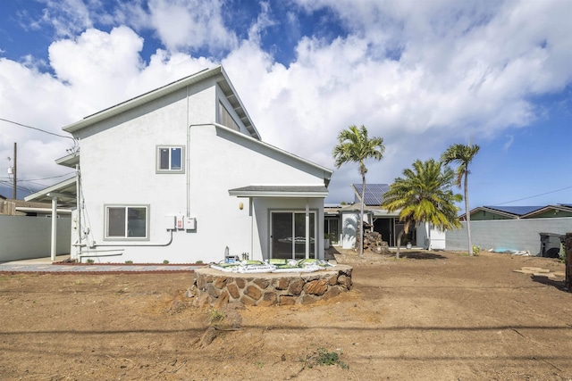 rear view of house featuring solar panels