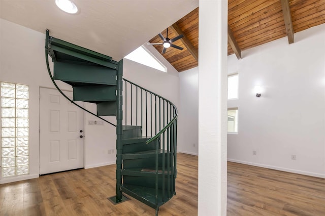 staircase with high vaulted ceiling, beamed ceiling, hardwood / wood-style flooring, ceiling fan, and wooden ceiling