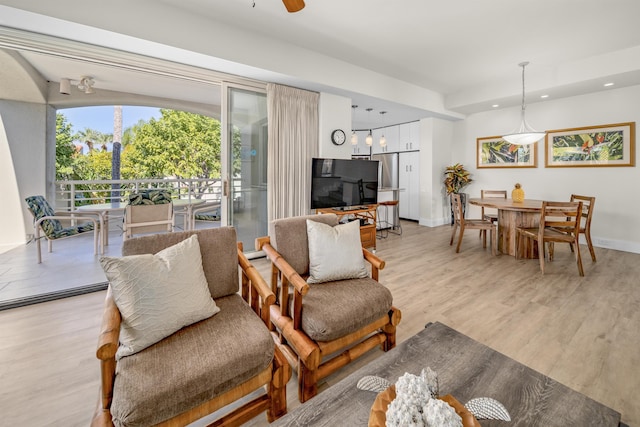 living room with light hardwood / wood-style floors and ceiling fan