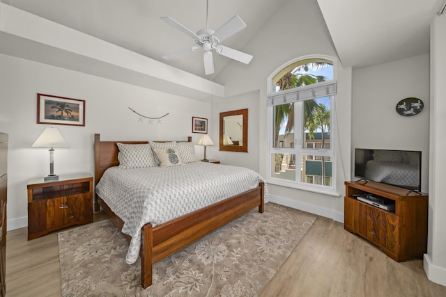 bedroom with high vaulted ceiling, ceiling fan, and light hardwood / wood-style flooring