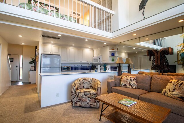 2230 S Kihei Rd Unit 9, Kihei, HI 96753 - living room featuring light colored carpet, a towering ceiling, and recessed lighting