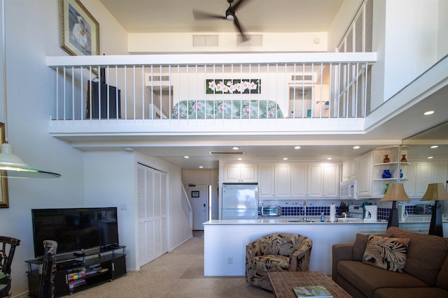 2230 S Kihei Rd Unit 9, Kihei, HI 96753 - living room featuring light carpet, ceiling fan, and a towering ceiling