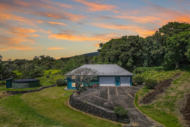 view of front of house featuring a garage, a yard, and an outdoor structure