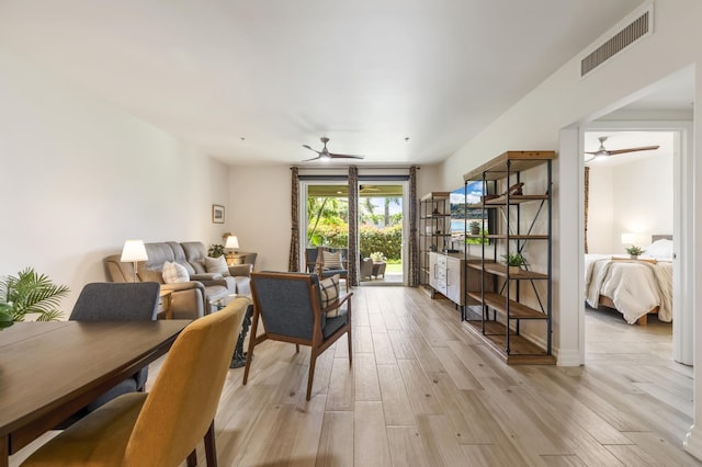 living area with a ceiling fan, visible vents, and light wood-style floors