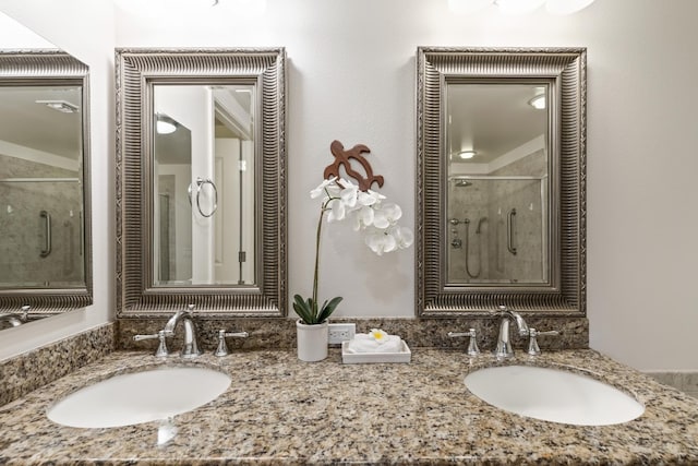 full bath with a stall shower, double vanity, and a sink