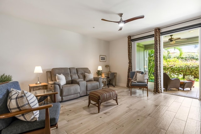 living area featuring ceiling fan, baseboards, and light wood-type flooring