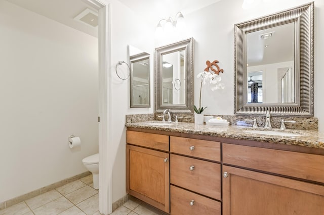 full bathroom featuring tile patterned floors, toilet, double vanity, and a sink