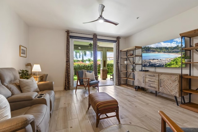 living room with light wood finished floors, ceiling fan, and baseboards