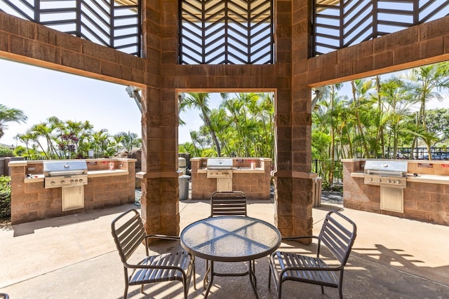view of patio with outdoor dining space, exterior kitchen, and grilling area