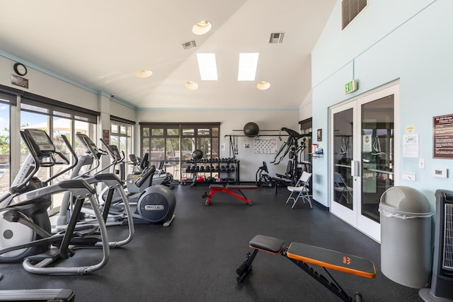 workout area featuring visible vents and vaulted ceiling with skylight