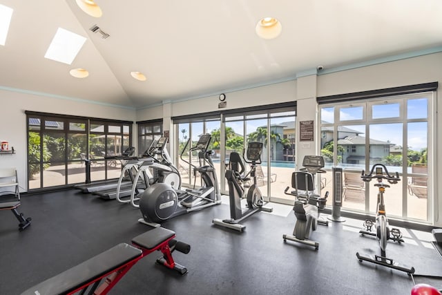 exercise room featuring visible vents, ornamental molding, a wealth of natural light, and lofted ceiling with skylight