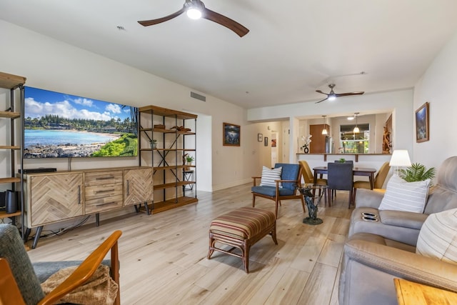 living area featuring visible vents, ceiling fan, and light wood-style floors