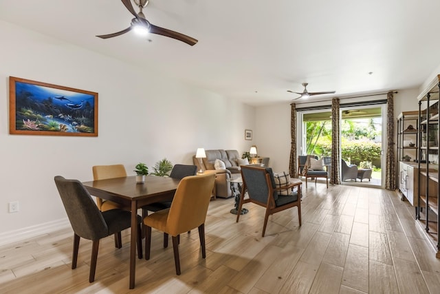 dining room featuring baseboards, ceiling fan, and light wood-style floors