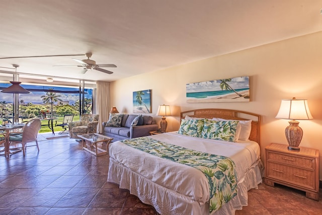 bedroom featuring stone finish flooring, access to outside, and ceiling fan