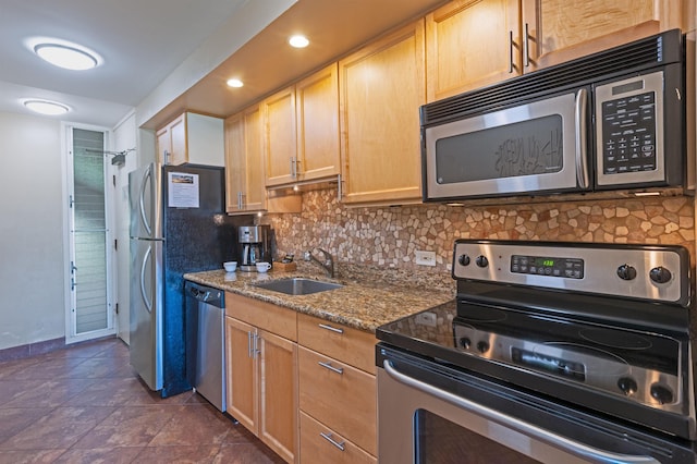 kitchen featuring a sink, backsplash, stainless steel appliances, and baseboards