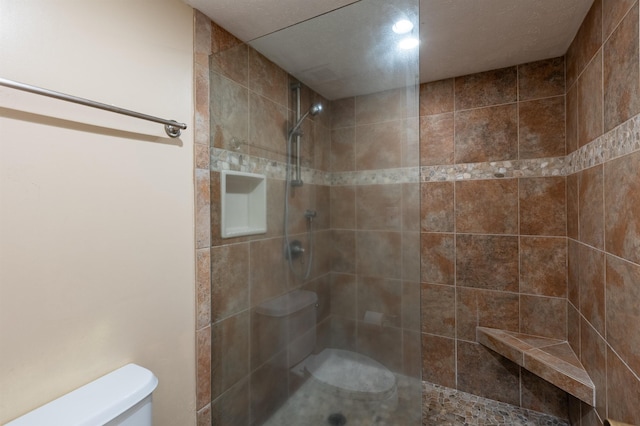 bathroom featuring toilet and tiled shower