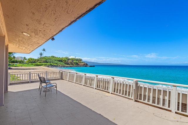 view of patio with a beach view and a water view
