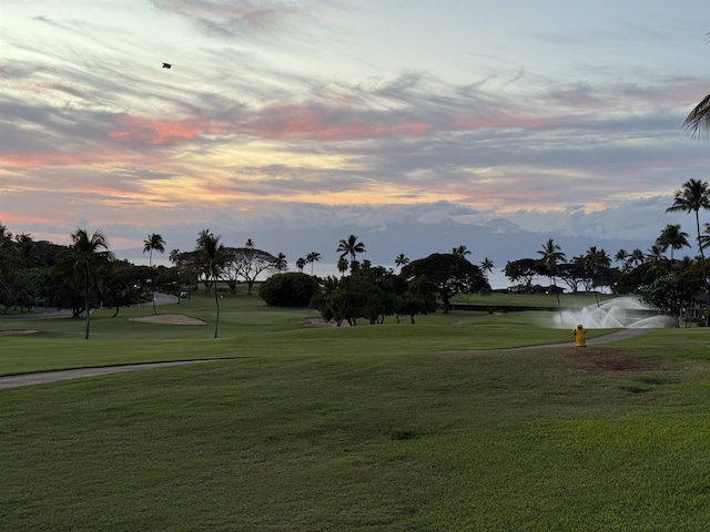 view of community with a yard and view of golf course