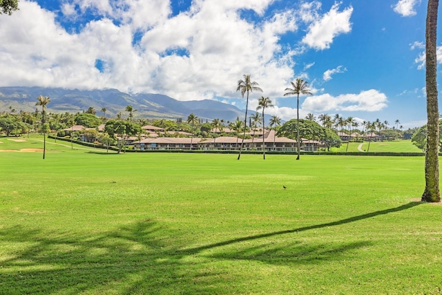 surrounding community with view of golf course, a mountain view, and a lawn
