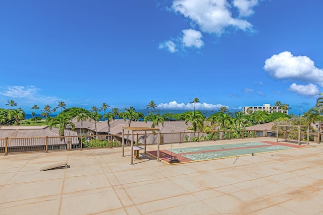 view of swimming pool with shuffleboard and fence