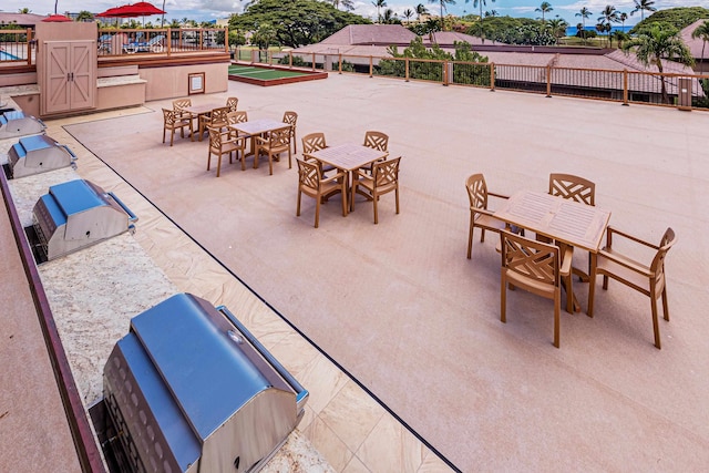 view of patio with fence, outdoor dining space, and exterior kitchen