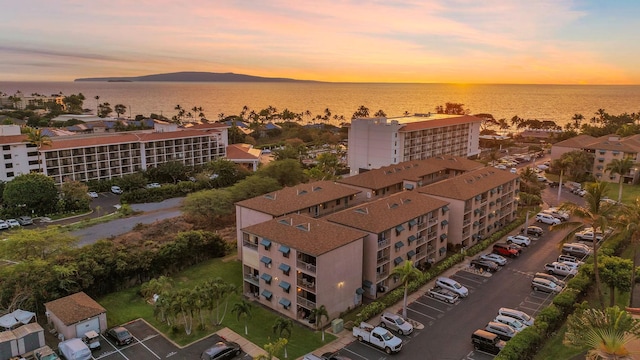 aerial view at dusk featuring a water view