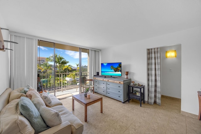 living area featuring light tile patterned floors, expansive windows, and baseboards