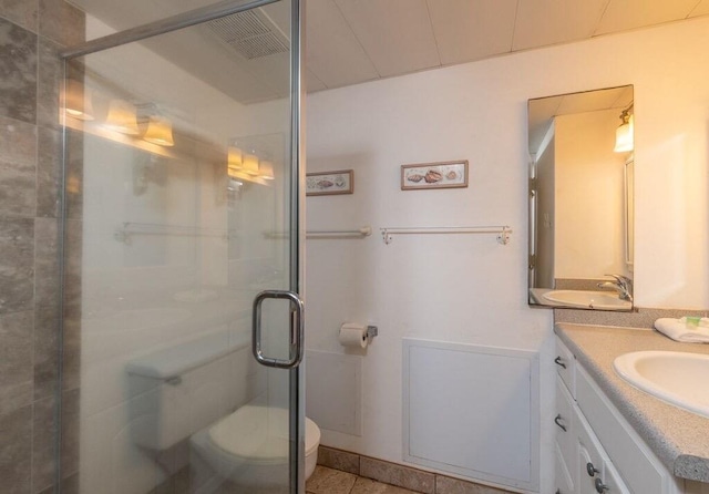 bathroom featuring walk in shower, tile patterned floors, vanity, and toilet