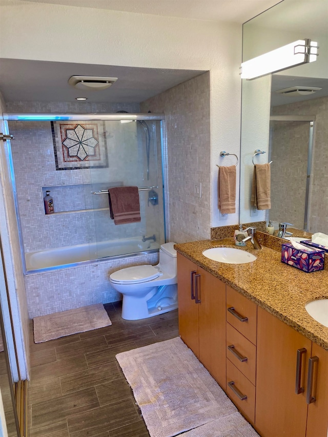 full bathroom with toilet, combined bath / shower with glass door, double vanity, and tile patterned floors