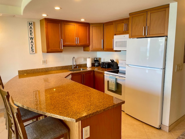 kitchen with sink, kitchen peninsula, white appliances, light tile patterned flooring, and dark stone countertops