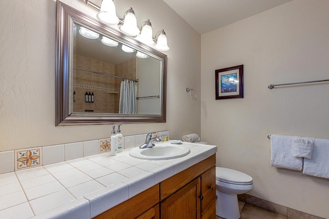 bathroom featuring vanity, tile patterned flooring, toilet, and curtained shower