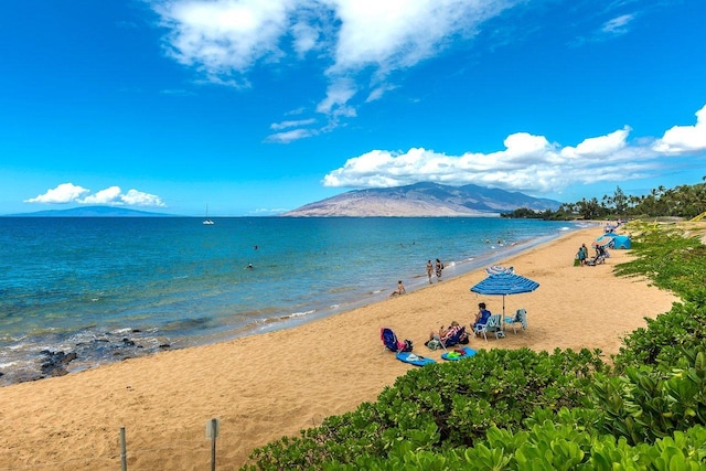 water view with a mountain view and a view of the beach