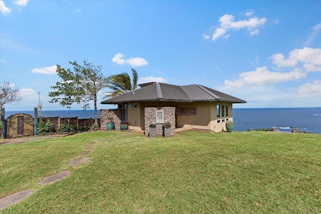 rear view of house with a lawn and a water view