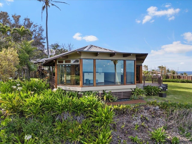 rear view of property featuring a wooden deck and a sunroom