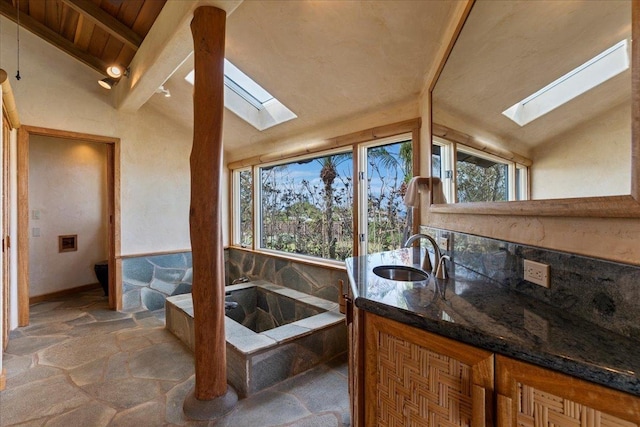 bathroom featuring vanity, a wealth of natural light, and vaulted ceiling with skylight