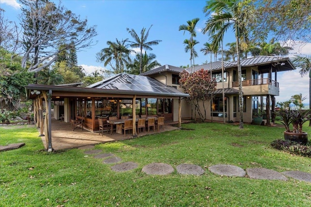 back of house featuring a yard, a patio area, and a balcony