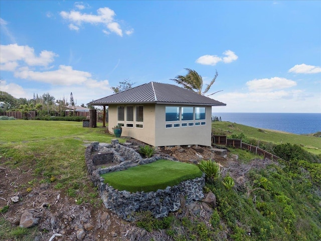 view of side of property featuring a lawn and a water view