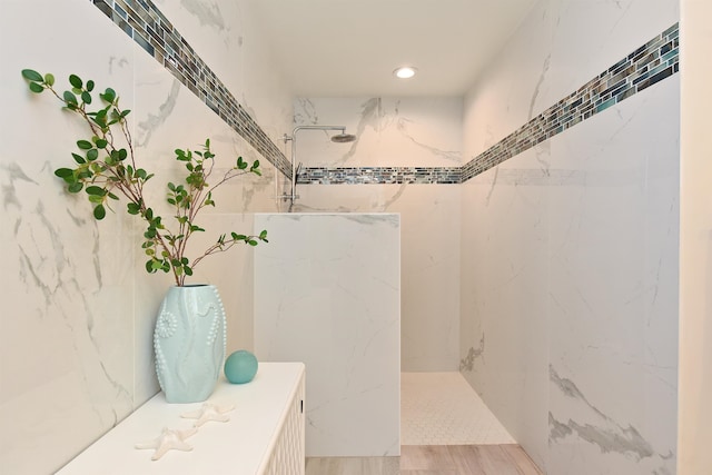 bathroom with hardwood / wood-style floors and tiled shower