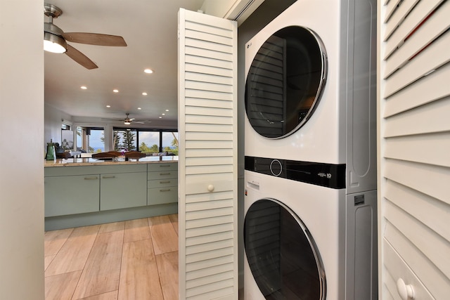 clothes washing area featuring light hardwood / wood-style floors, stacked washer / dryer, and ceiling fan