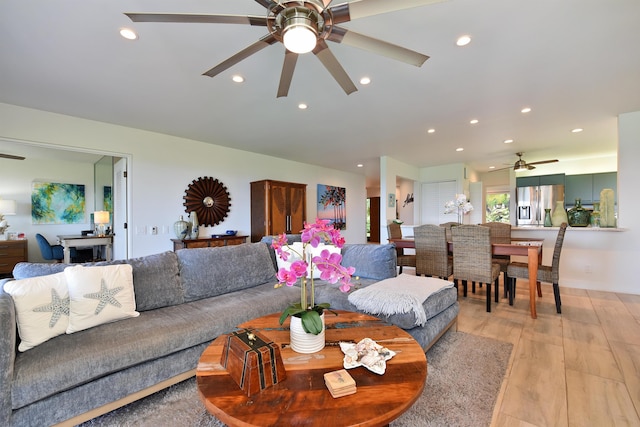 living room featuring ceiling fan and light hardwood / wood-style floors