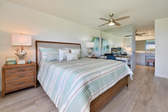 bedroom with light wood-type flooring, ensuite bathroom, and ceiling fan