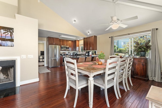 dining space featuring a premium fireplace, ceiling fan, dark hardwood / wood-style floors, and high vaulted ceiling