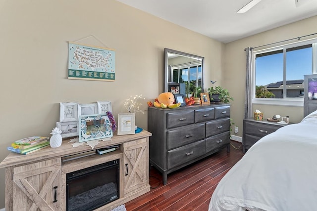 bedroom with dark hardwood / wood-style flooring and ceiling fan