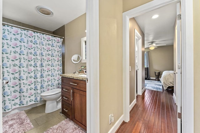 bathroom with vanity, curtained shower, hardwood / wood-style floors, toilet, and ceiling fan