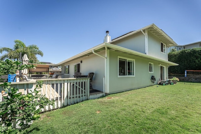 rear view of house with a lawn and a deck