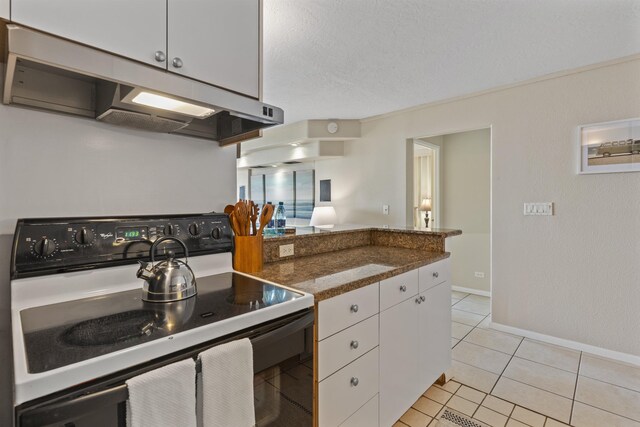 kitchen featuring electric range oven, white cabinetry, light tile patterned floors, kitchen peninsula, and a textured ceiling